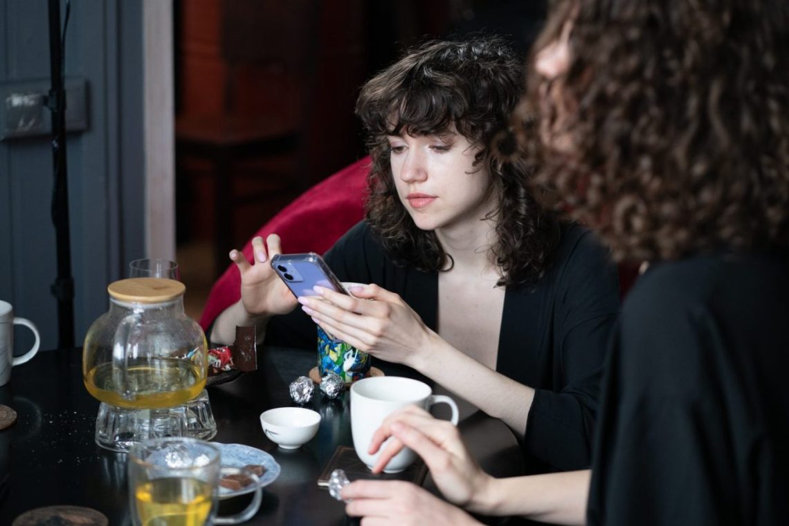 Une consultante échange avec une médium autour de cartes de tarot à Paris.
