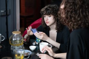 Une consultante échange avec une médium autour de cartes de tarot à Paris.
